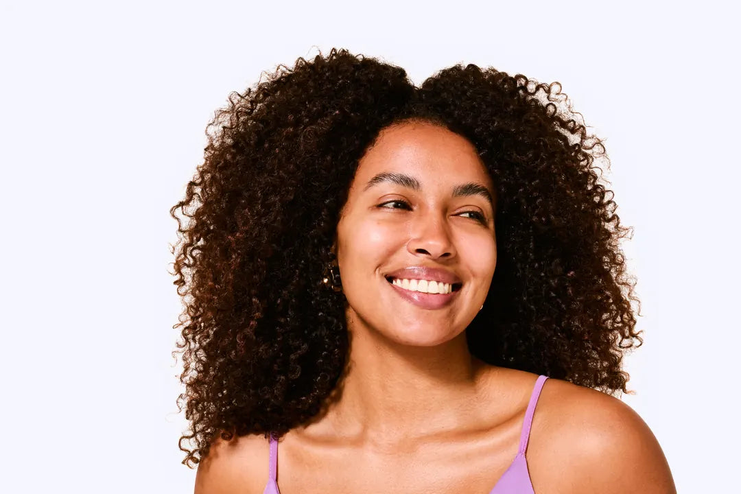 Mulher sorridente com cabelos cacheados volumosos e soltos, antes e depois de usar Ollie