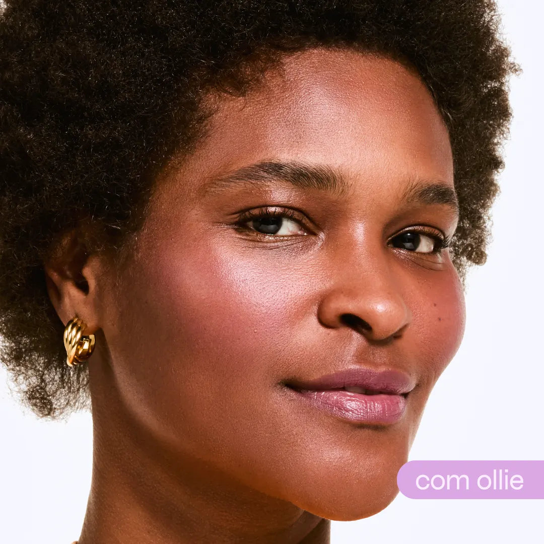 Rosto frontal com blush rosado, lábios vinho glossy e brilho dourado nós olhos — bastão com cor Ollie
