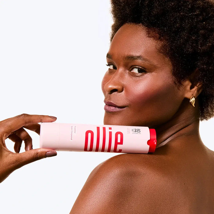 Modelo segurando Protetor Solar Hidratante Corporal FPS 60 da Ollie, destacando sua pele suave e hidratada.