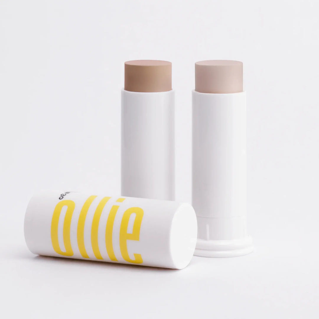 Dois bastões com cor FPS 95 FPUVA 40 da Ollie em fundo branco. Textura aveludada e cobertura de base.